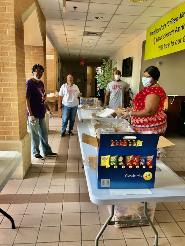 Volunteers practice CDC health guidelines with masks, gloves and social distancing as they prepare meals for the neighborhood feeding program at Hamilton Park UMC in Dallas, TX. The church started its feeding program March 23, 2020, to aid its neighbors who needed food during the coronavirus pandemic.